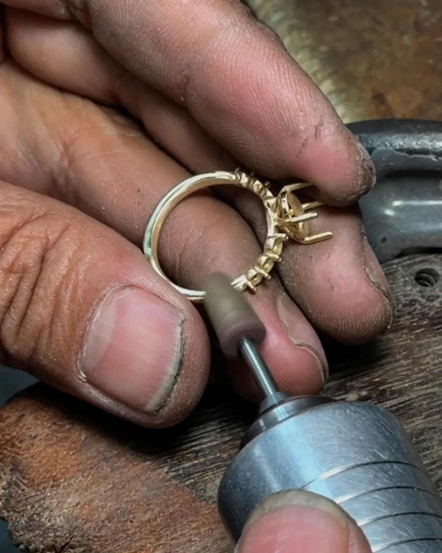 Artisan polishing a gold ring by hand