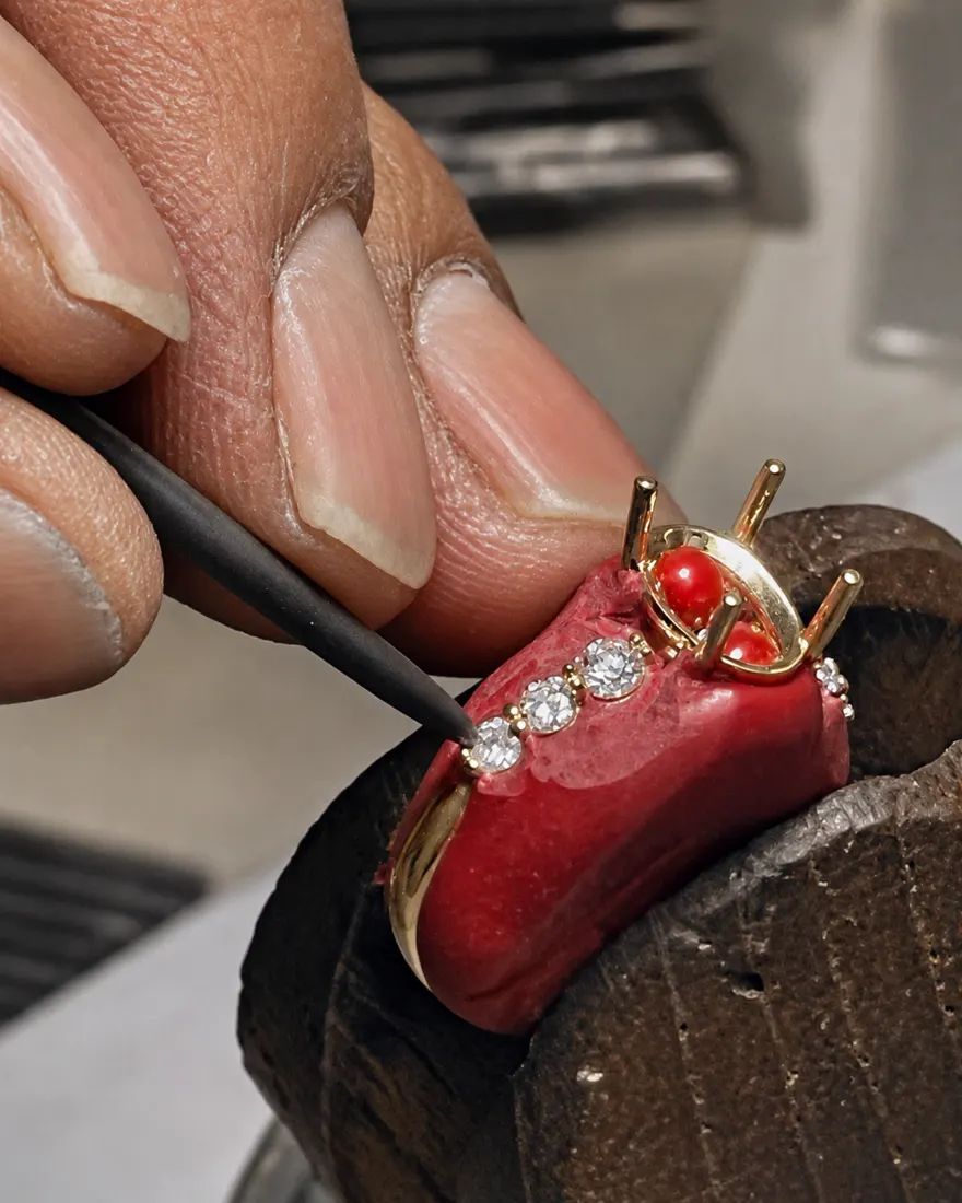 Artisan hand-setting diamonds into a gold ring